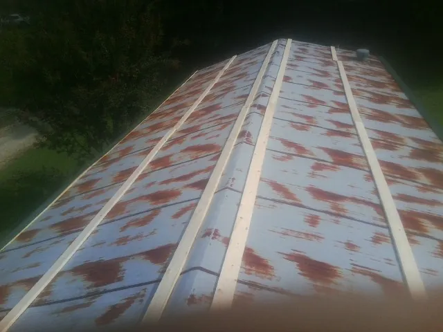 Rusted metal roof panels with new wood purlins before replacement — Storm Damage Roof Repair in Flournoy by Roofing Brothers
